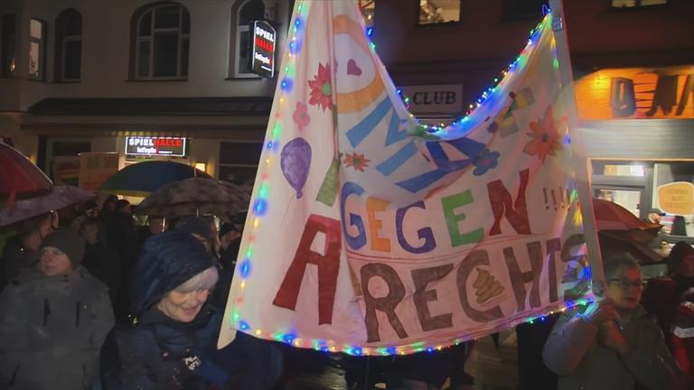 Auf dem Bild ist eine Demo mit Menschen zu sehen.