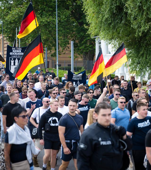 Demo-Teilnehmer der AfD-Jugendorganisation Generation Deutschland ziehen mit Deutschlandflaggen durch die Schweriner Innenstadt.