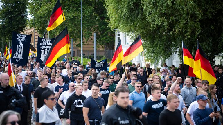 Demo-Teilnehmer der AfD-Jugendorganisation Generation Deutschland ziehen mit Deutschlandflaggen durch die Schweriner Innenstadt.