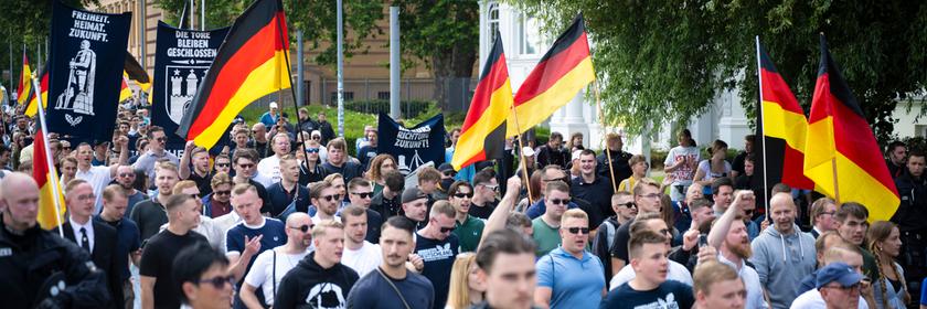 Demo-Teilnehmer der AfD-Jugendorganisation Generation Deutschland ziehen mit Deutschlandflaggen durch die Schweriner Innenstadt.