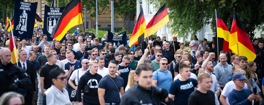 Demo-Teilnehmer der AfD-Jugendorganisation Generation Deutschland ziehen mit Deutschlandflaggen durch die Schweriner Innenstadt.