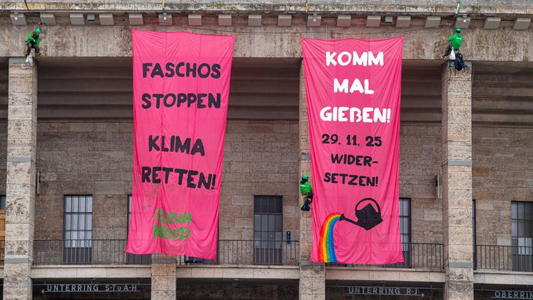 Aktivisten mobilisieren für einen Gegenprotest gegen die Neugründung der AfD-Jugend in Gießen - Banner am Olympiastadion in Berlin mit der Aufschrift: "Faschos stoppen, Klima retten, komm mal Gießen, 29.11.2025 widersetzen"
