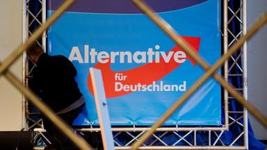 Mann montiert Parteilogo der AfD