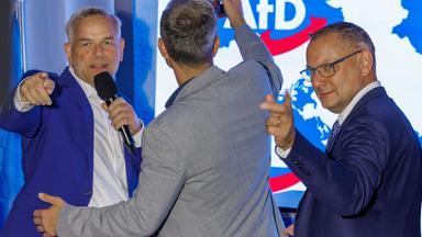 20.09.2026, Mecklenburg-Vorpommern, Schwerin: Leif-Erik Holm (l), Ministerpräsidentenkandidat der AfD für die Landtagswahl in Mecklenburg-Vorpommern, Enrico Schult (M), der Spitzenkandidat der AfD im Landtag von Mecklenburg-Vorpommern, und Tino Chrupalla (r), Vorsitzender der AfD-Bundestagsfraktion, stehen auf der Bühne der Wahlparty nach der Landtagswahl in Mecklenburg-Vorpommern.