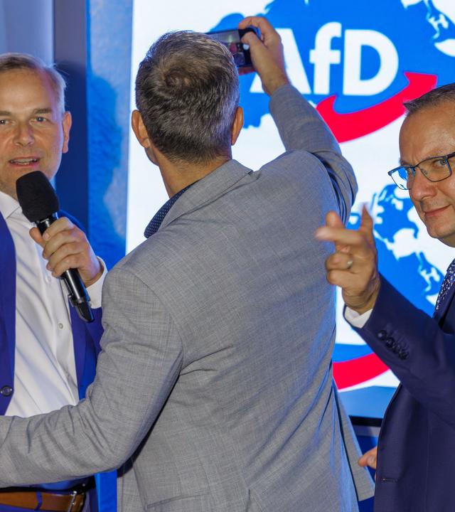 20.09.2026, Mecklenburg-Vorpommern, Schwerin: Leif-Erik Holm (l), Ministerpräsidentenkandidat der AfD für die Landtagswahl in Mecklenburg-Vorpommern, Enrico Schult (M), der Spitzenkandidat der AfD im Landtag von Mecklenburg-Vorpommern, und Tino Chrupalla (r), Vorsitzender der AfD-Bundestagsfraktion, stehen auf der Bühne der Wahlparty nach der Landtagswahl in Mecklenburg-Vorpommern.