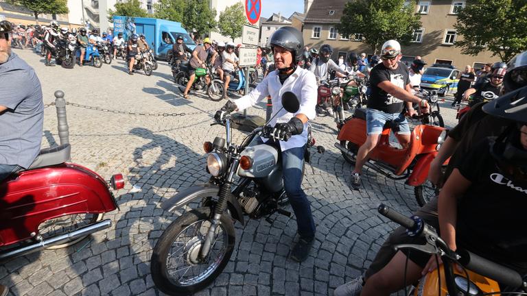 Thüringen, Greiz: Björn Höcke, Vorsitzender der AfD in Thüringen, sitzt mit einem Motorradhelm auf dem Kopf auf einem Moped Simson