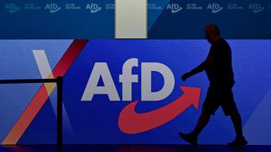 Ein Mann läuft auf einer Bühne einer AfD-Veranstaltung.