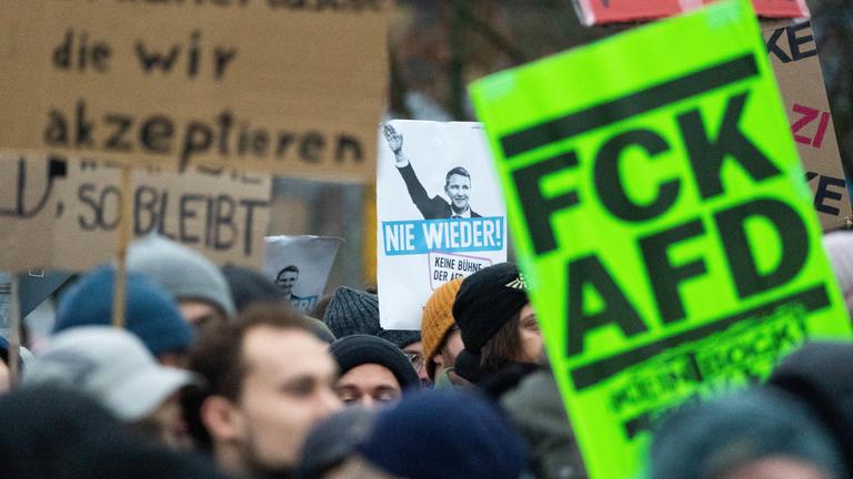 Menschen, die gegen die Jugendorganisation der Afd namens "Neue Generation" protestieren. Sie laufen und halten mehrere Plakate. 