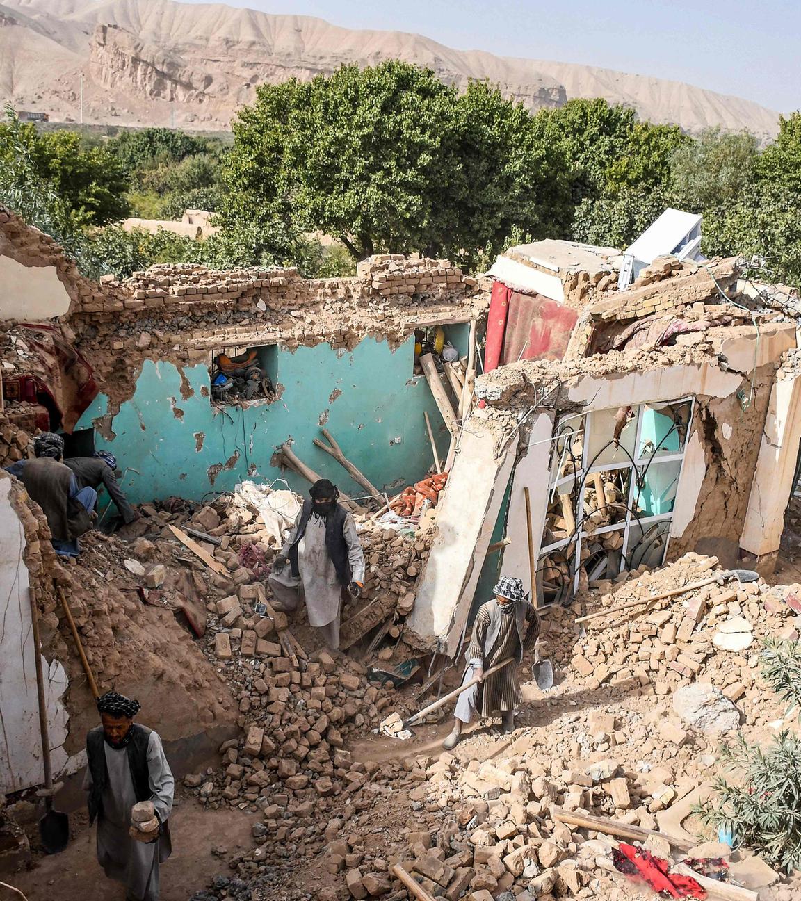 Überlebende des Erdbebens in Afghanistan durchsuchen am 03.11.2025 die Trümmer eines zerstörten Hauses in einem Dorf in Tashqurghan im Bezirk Khulm in der Provinz Samangan.