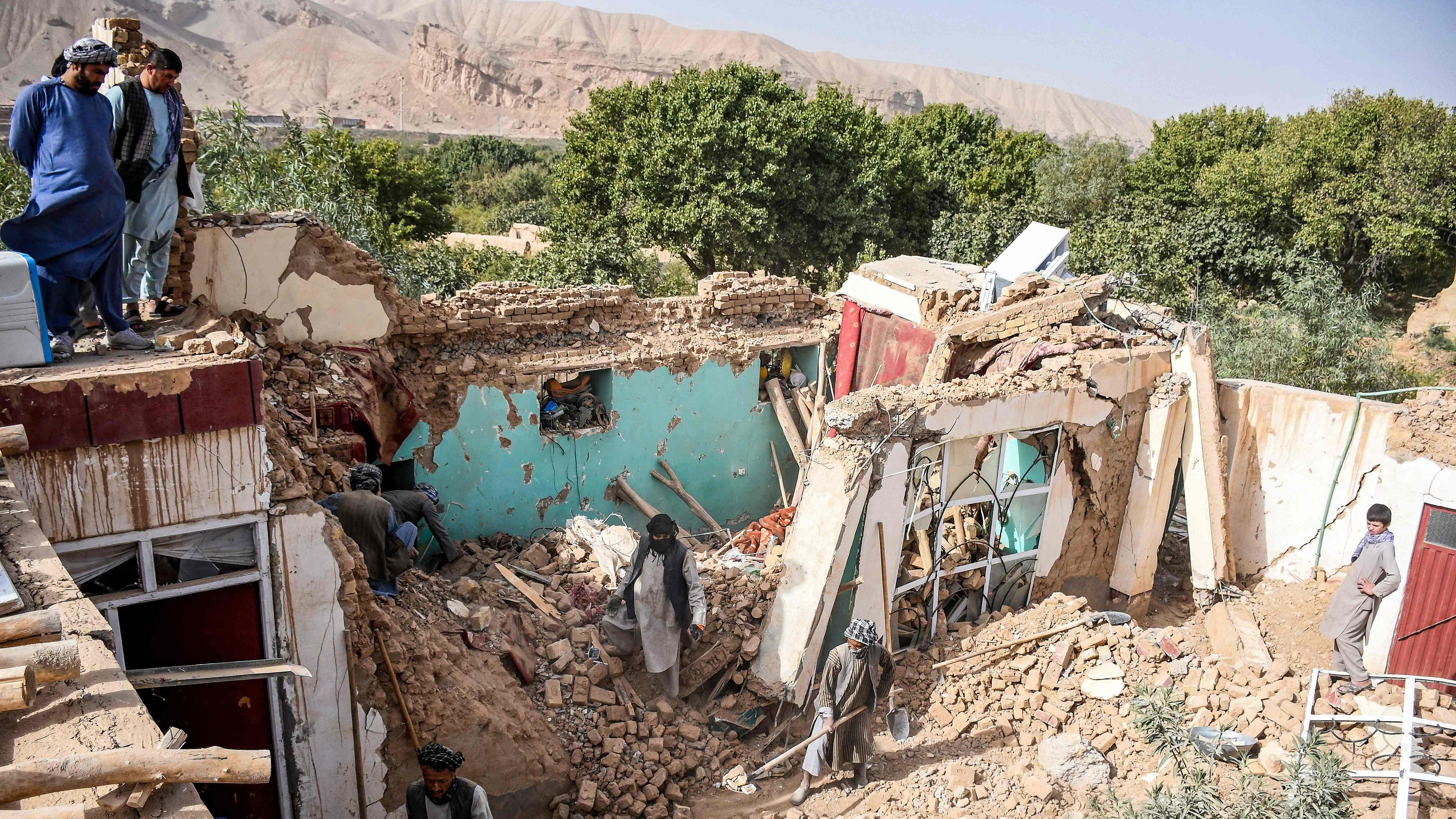Überlebende des Erdbebens in Afghanistan durchsuchen am 03.11.2025 die Trümmer eines zerstörten Hauses in einem Dorf in Tashqurghan im Bezirk Khulm in der Provinz Samangan.