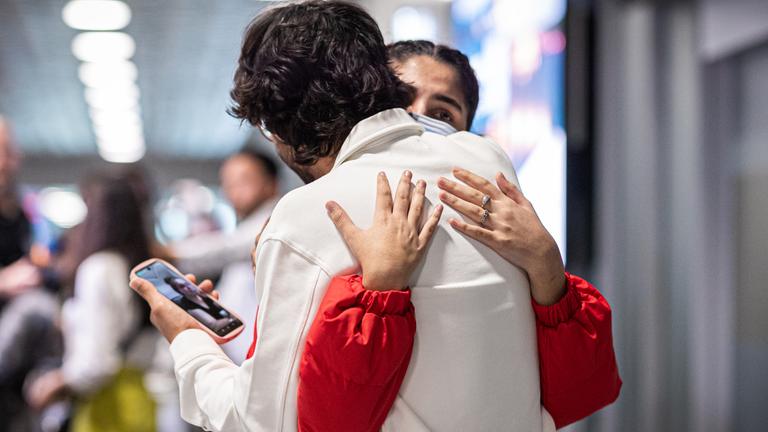 Menschen aus Afghanistan, die mit einem Flugzeug in Hannover gelandet sind, umarmen sich.
