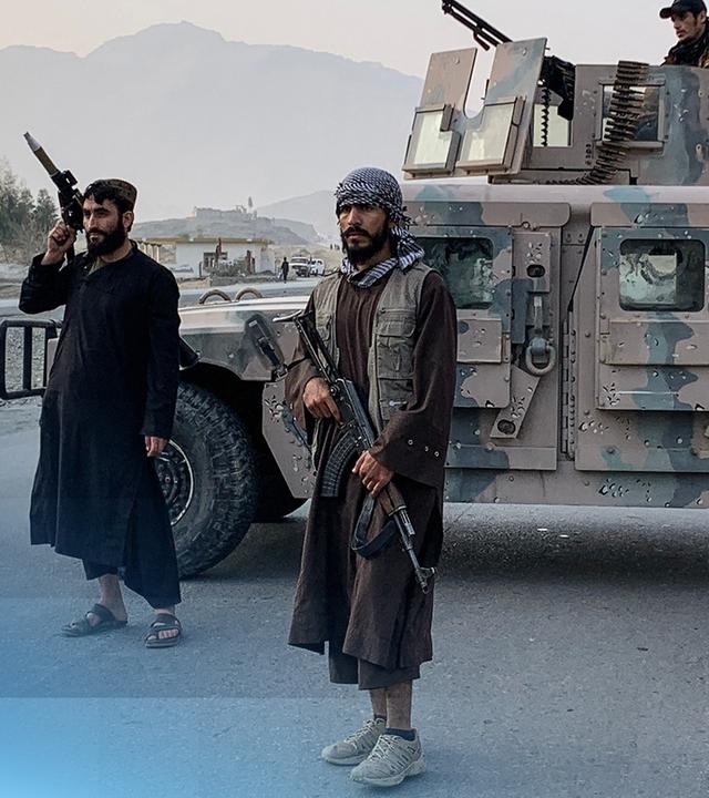 bewaffnete Soldaten auf einer Straße mit einem Militärjeep die Straße blockierend.