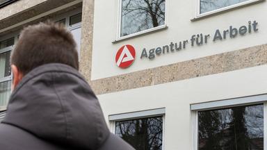 Ein Mann steht vor einem Gebäude der Agentur für Arbeit. (Symbolbild)