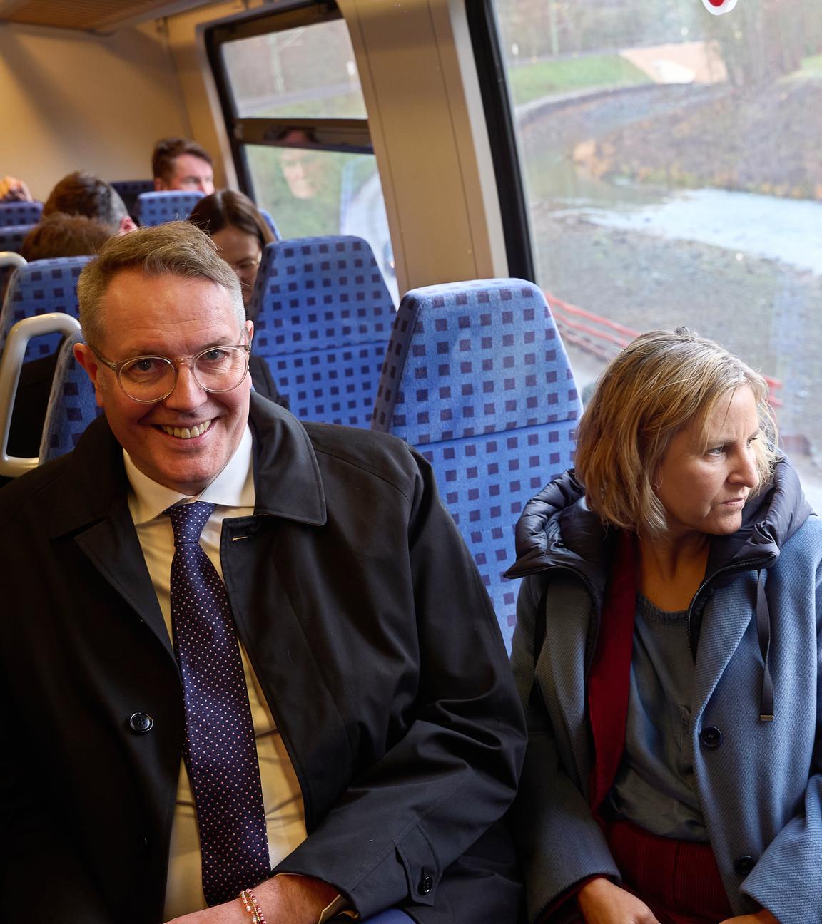 Alexander Schweitzer (l, SPD), Ministerpräsident von Rheinland-Pfalz, und Katrin Eder (Bündnis 90/Die Grünen), Umweltministerin von Rheinland-Pfalz, sitzen bei der Inbetriebnahme der Ahrtalbahn in einer Regionalbahn. 