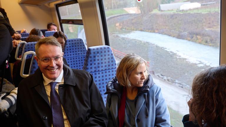 Alexander Schweitzer (l, SPD), Ministerpräsident von Rheinland-Pfalz, und Katrin Eder (Bündnis 90/Die Grünen), Umweltministerin von Rheinland-Pfalz, sitzen bei der Inbetriebnahme der Ahrtalbahn in einer Regionalbahn. 