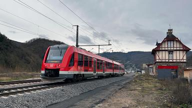 Ein Zug der Ahrtalbahn steht auf einem Gleis im Ahrtal vor ihrer Wiedereröffnung.