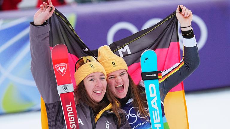 Emma Aicher und Kira Weidle-Winkelmann jubeln über ihre Silbermedaille am 10.02.2026 in Cortina D'ampezzo.
