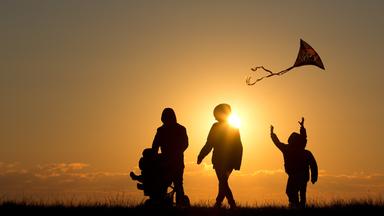 familie mit kinderwagen bei sonnenuntergang