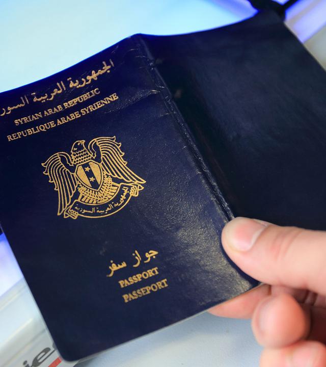 syrischer pass wird auf echtheit geprueft - symbolfoto