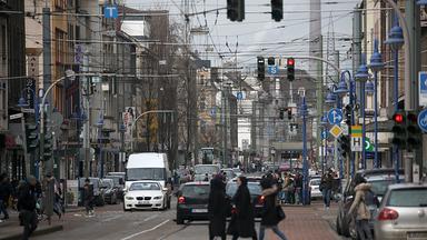 passanten ueberqueren die weseler strasse im stadteil marxloh - duisburg