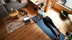 frau trainiert zuhause mithilfe eines online-videos