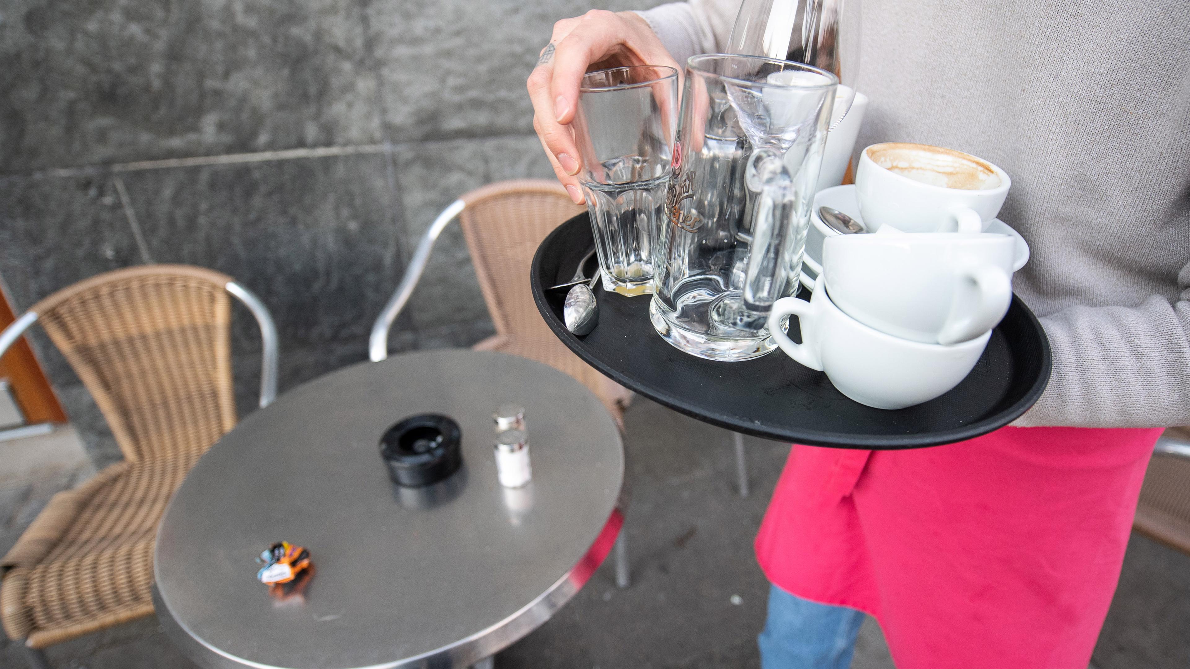 kellner raeumt tisch ab