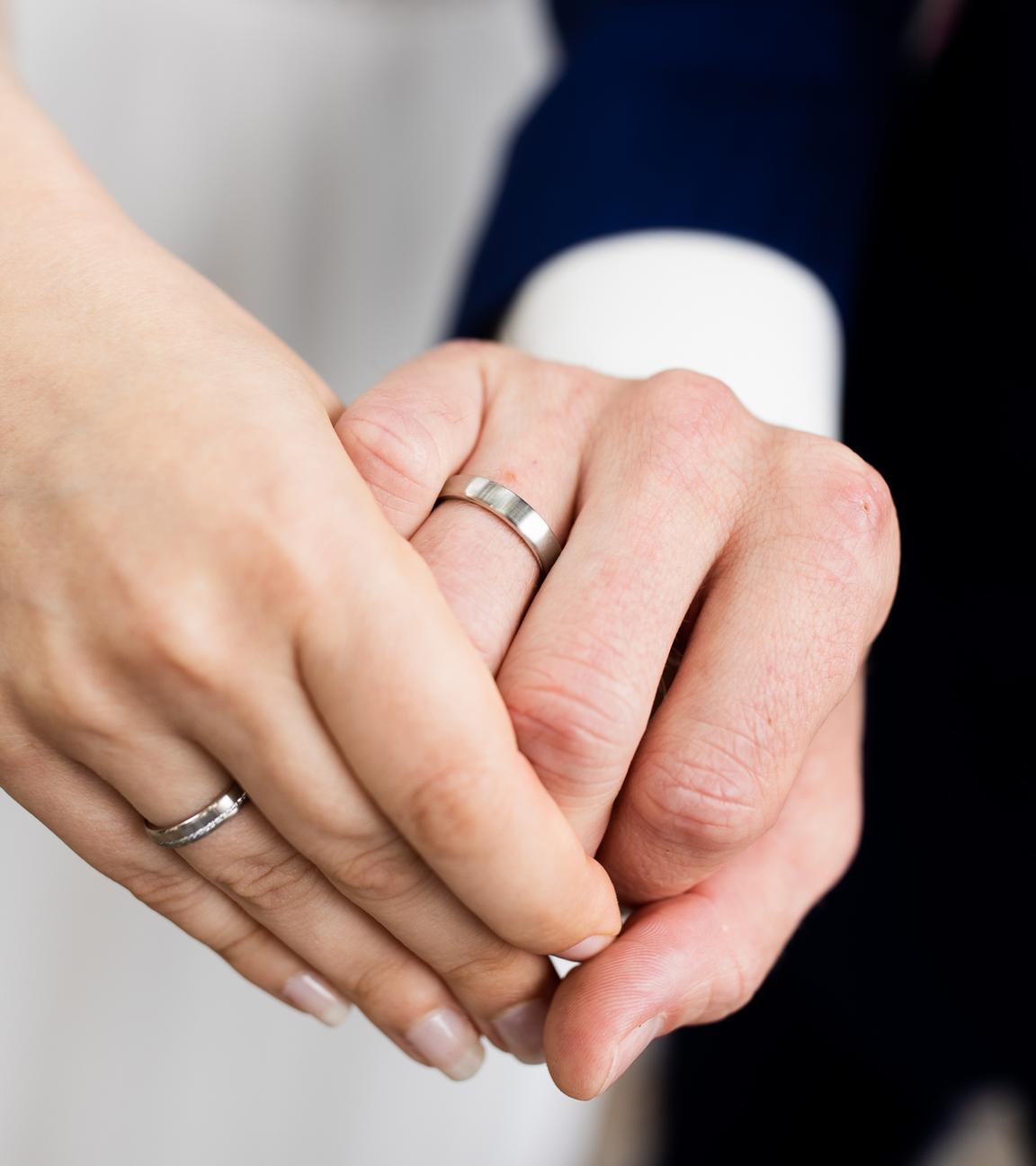 Brautpaar zeigt die Eheringe