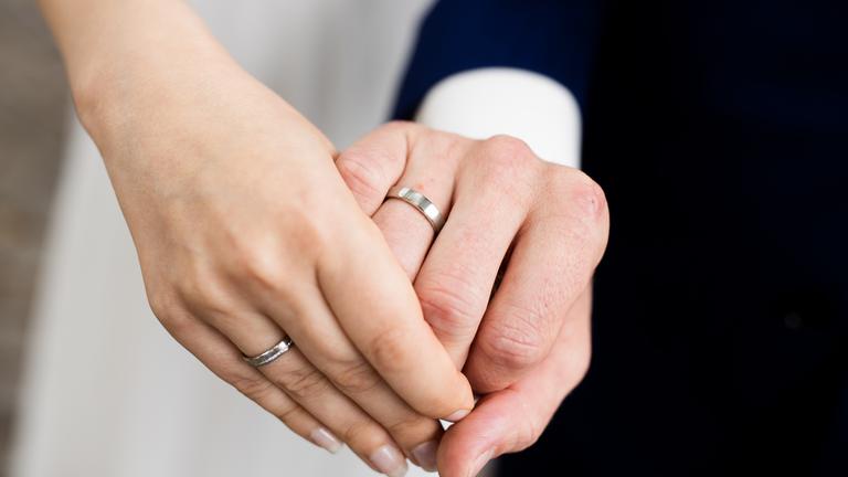 Brautpaar zeigt die Eheringe