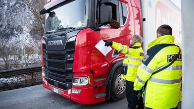 Polizisten kontrollieren einen LKW an der Grenze zu Tirol