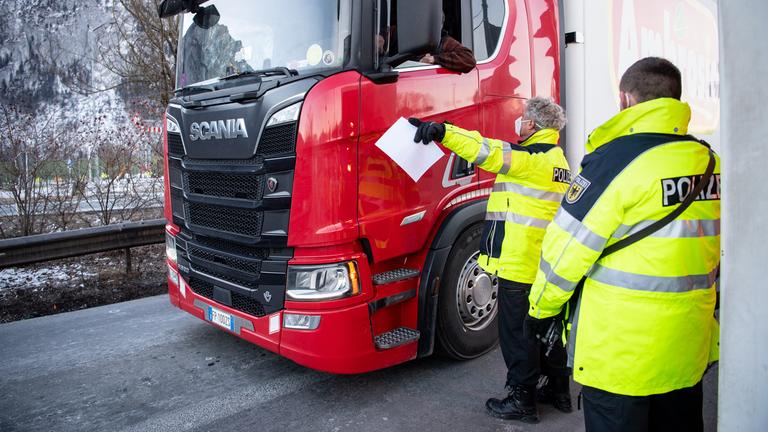 Polizisten kontrollieren einen LKW an der Grenze zu Tirol