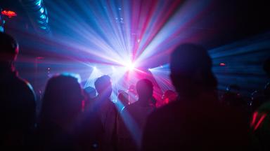 Tanzende Clubbesucher im Lichteffekt