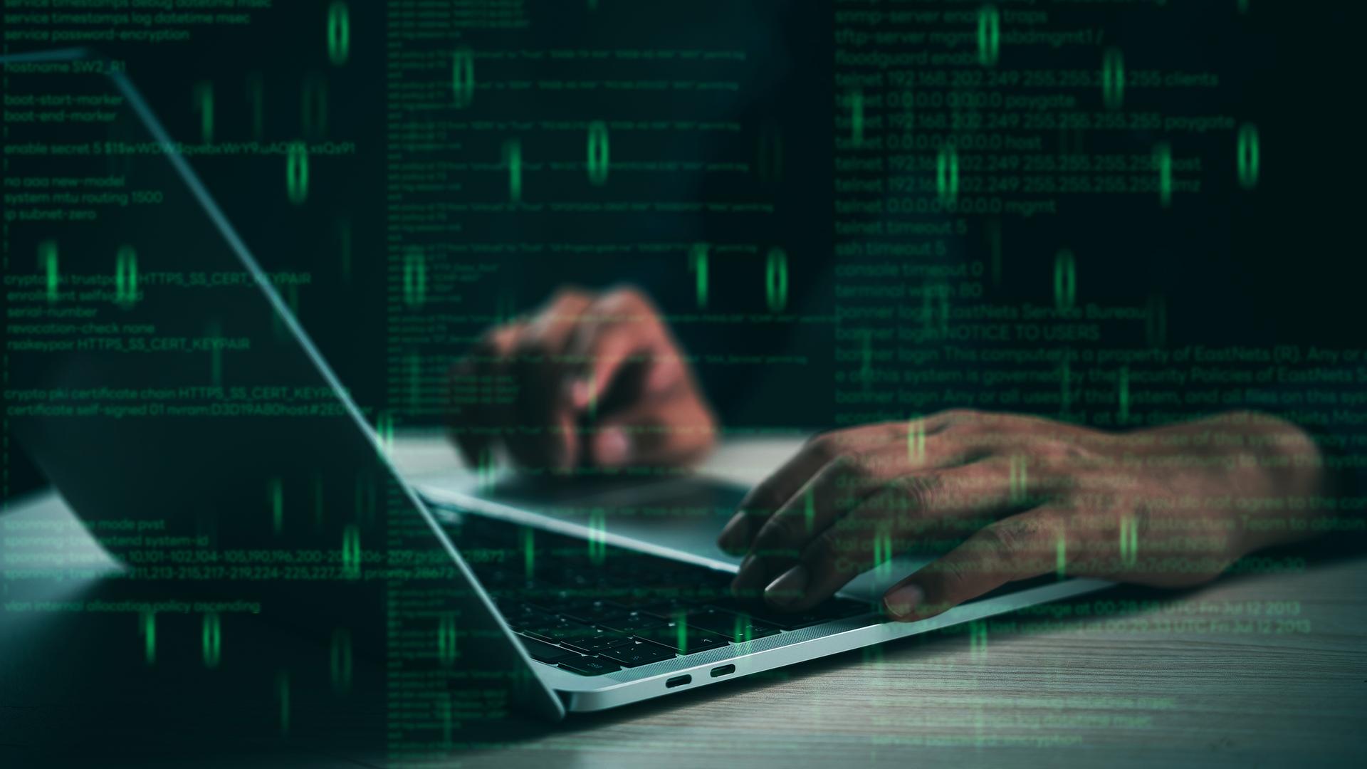 Hände tippen auf einem Laptop mit schwebendem Code, der für Programmierung und Cybersicherheit steht