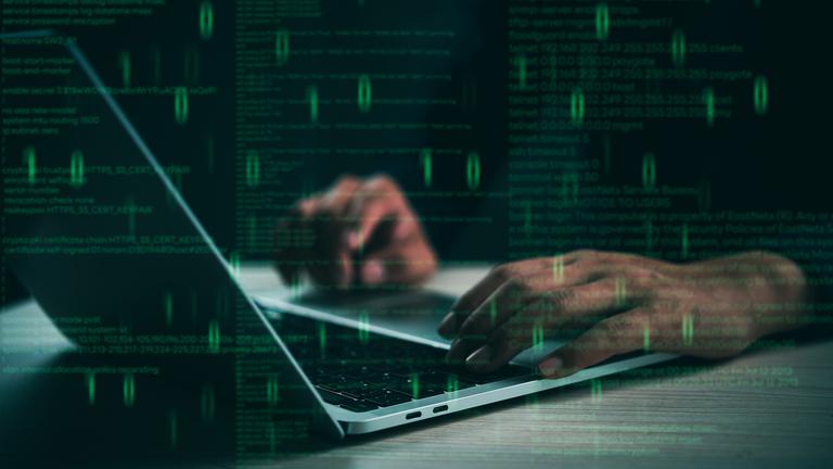 Hände tippen auf einem Laptop mit schwebendem Code, der für Programmierung und Cybersicherheit steht