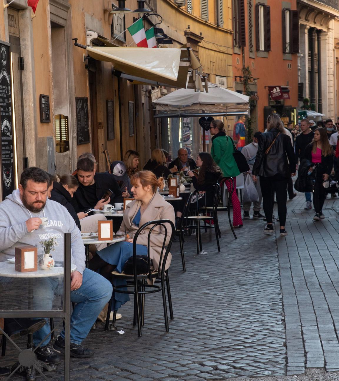 Menschen sitzen im Strassencafé in Rom