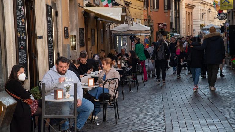 Menschen sitzen im Strassencafé in Rom