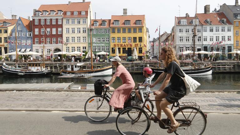 Frauen auf Fahrrädern am Nyhavn in Kopenhagen