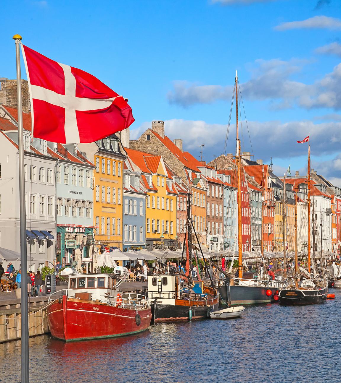 Nyhavn in Kopenhagen an einem sonnigen Tag es ist die dänische Flagge zu sehen. 