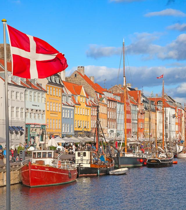 Nyhavn in Kopenhagen an einem sonnigen Tag es ist die dänische Flagge zu sehen. 