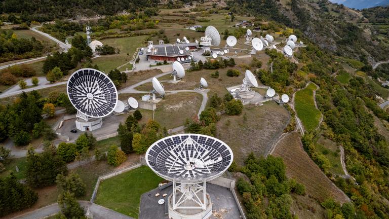 Employees of local electricity producer CKW install solar panels in a satellite dish in Leuk