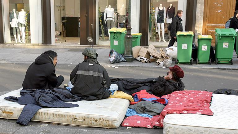 obdachlose vor einem modegeschaeft in paris