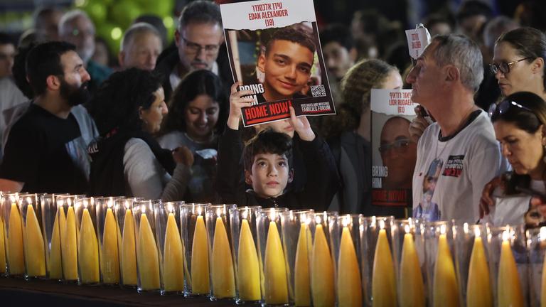 Menschen an einer Gedenkstätte zum Gedenken an die entführten Opfer