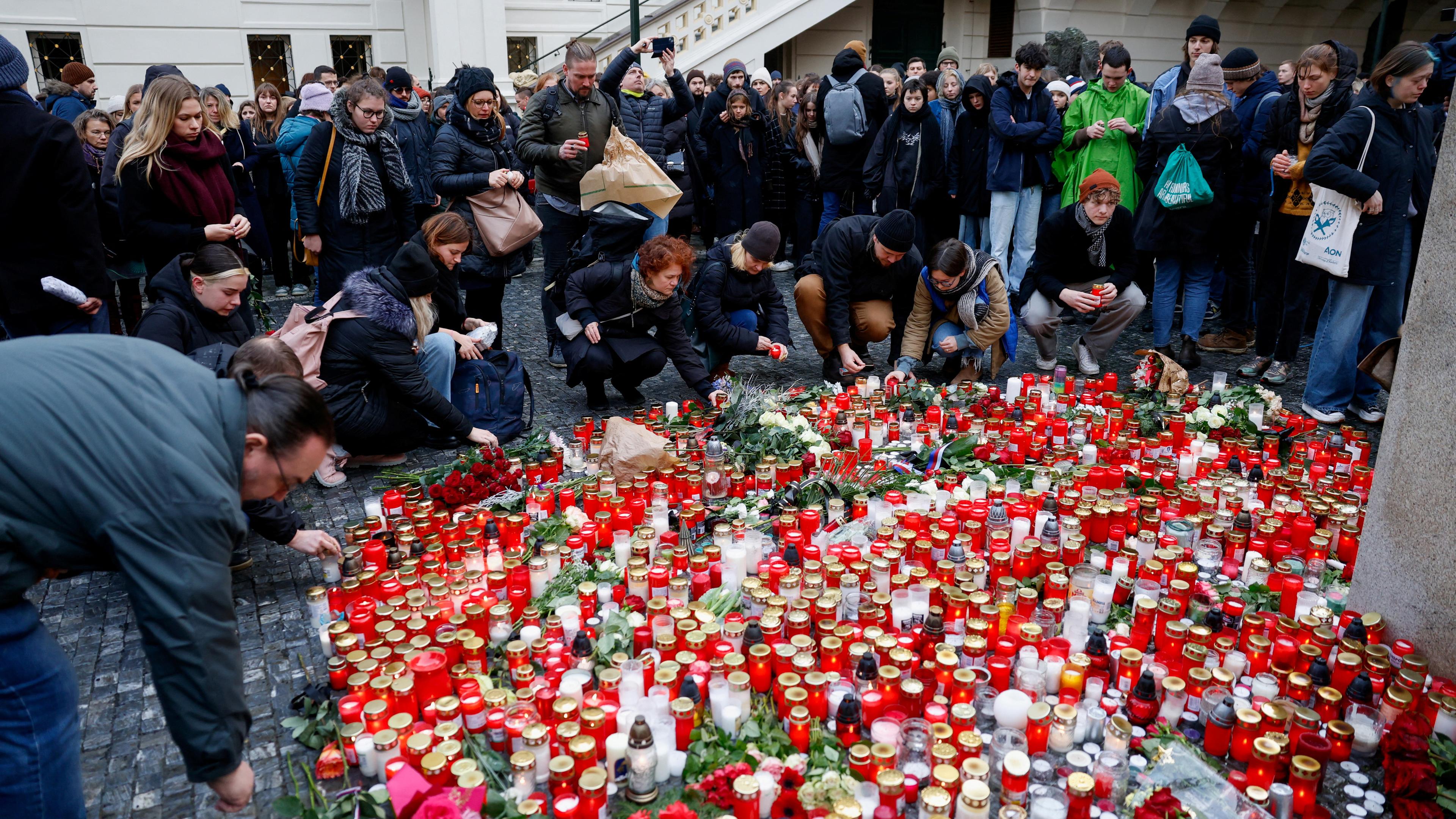 People hold a vigil to honour victims of Prague shooting