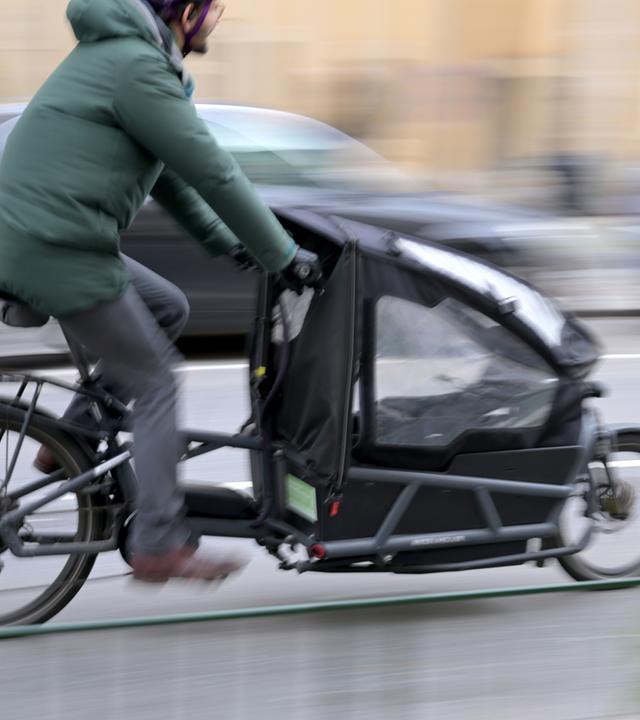 Mann fährt auf Lastenfahrrad