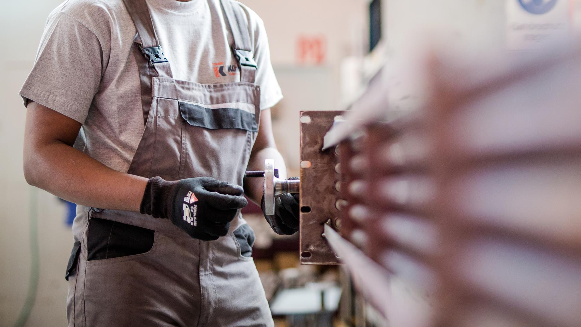 Ein Geflüchteter aus Somalia arbeitet während eines Praktikums bei einem Industrieunternehmen.