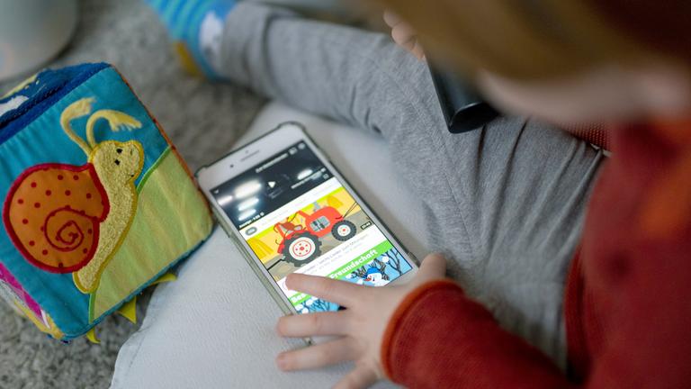 Kind schaut Videos auf einem Smartphone an
