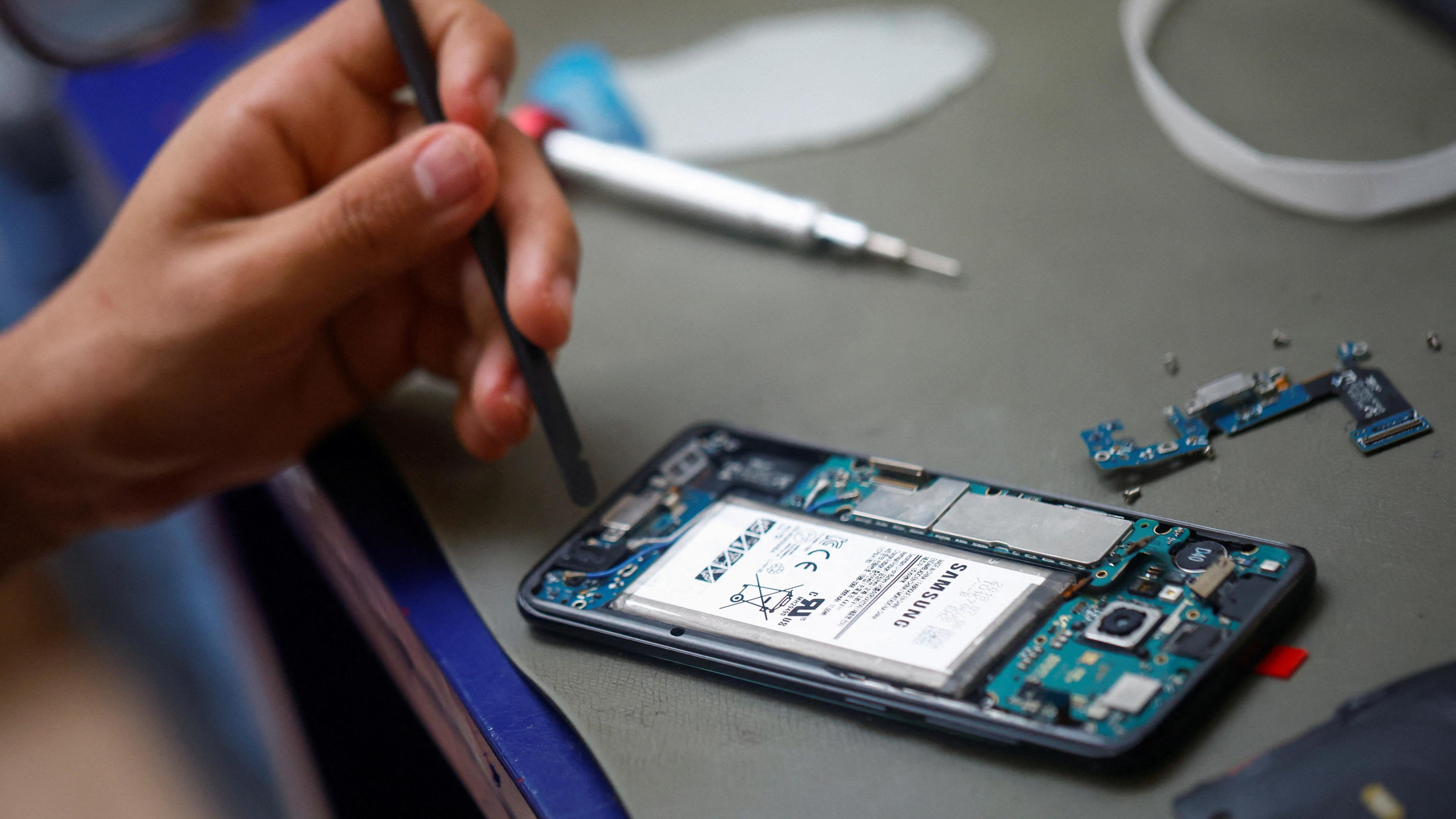 A smartphone repair technician works on a Samsung Electronics' Galaxy S8 in Saint-Sebastien-sur-Loire
