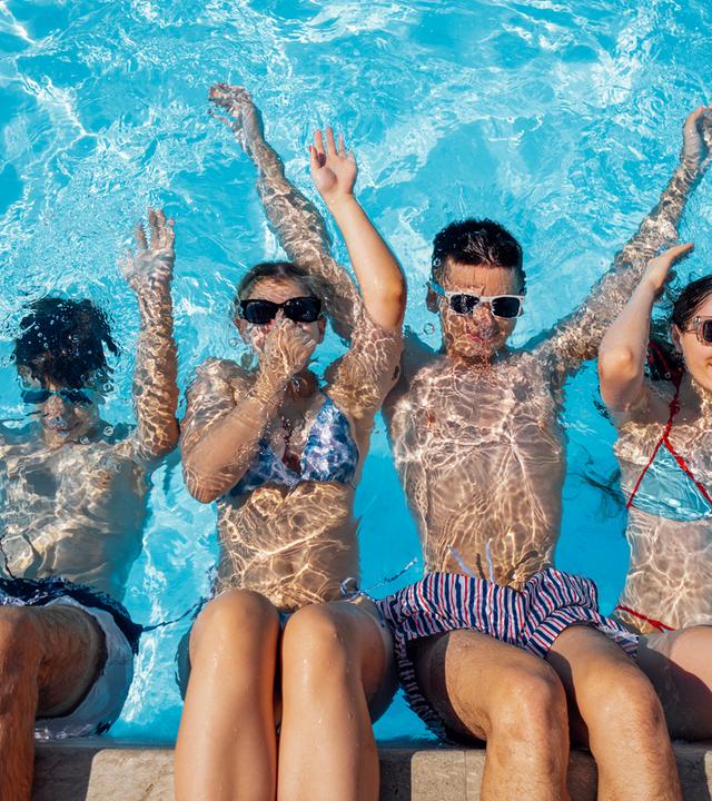 Teenager mit Sonnenbrillen im Pool