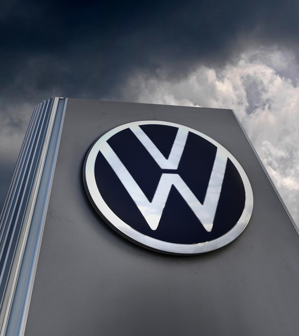VW-Schild vor dunklen Wolken - Fotomontage Symbol Autokrise