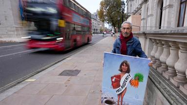 Britain Budget Politics: Ein Mann in London mit einem Bild/Schild