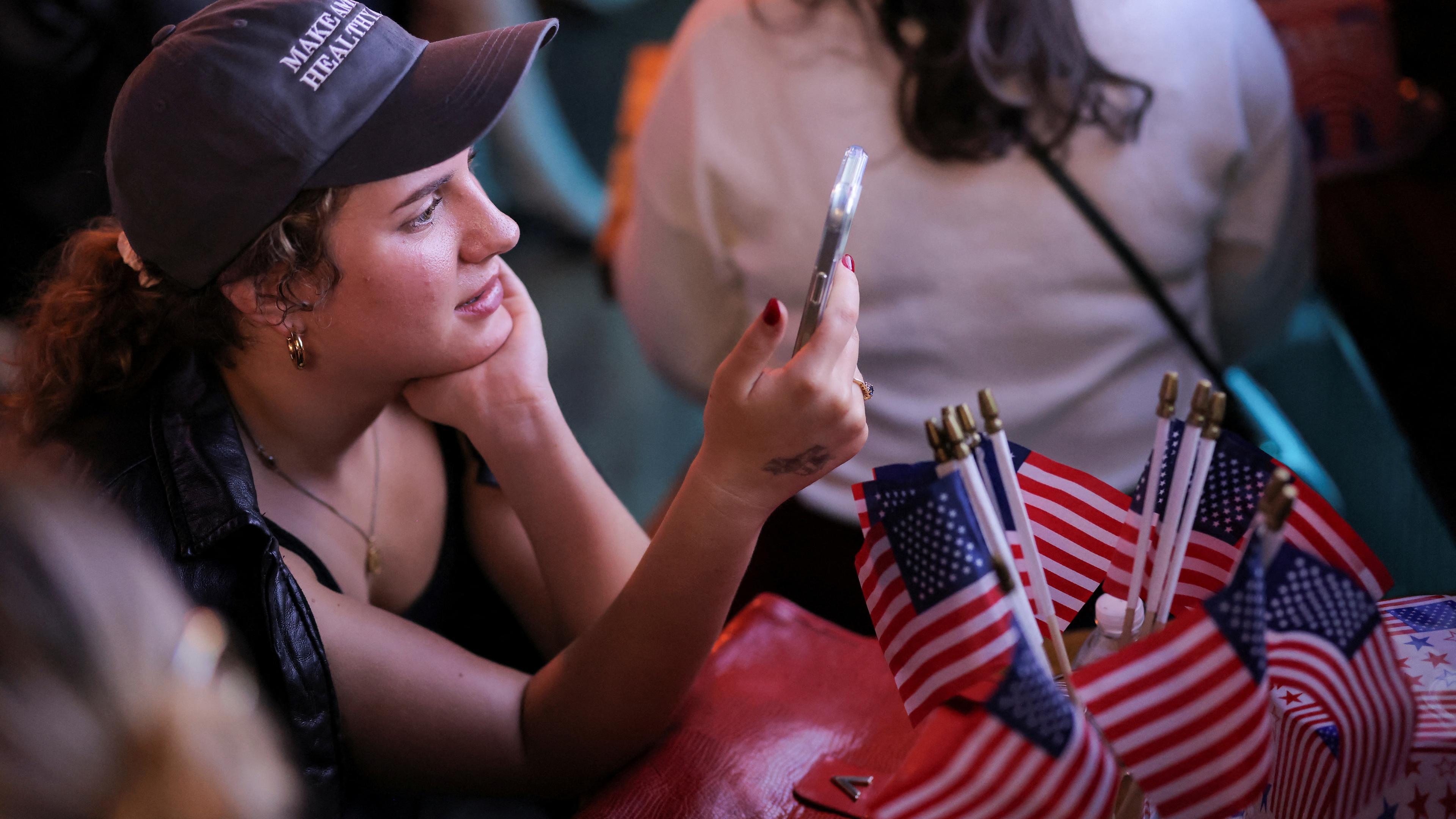 Frau, die die US-Wahlergebnisse auf dem Handy verfolgt